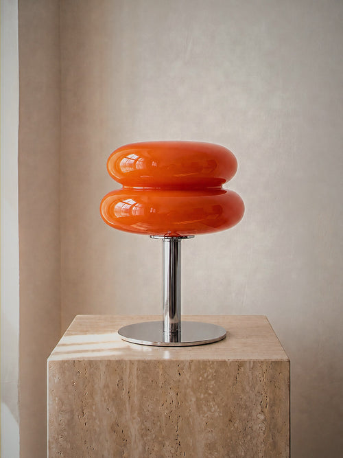 Carrara, two stacked orange glass rings on a polished chrome stem with a round chrome base, unlit