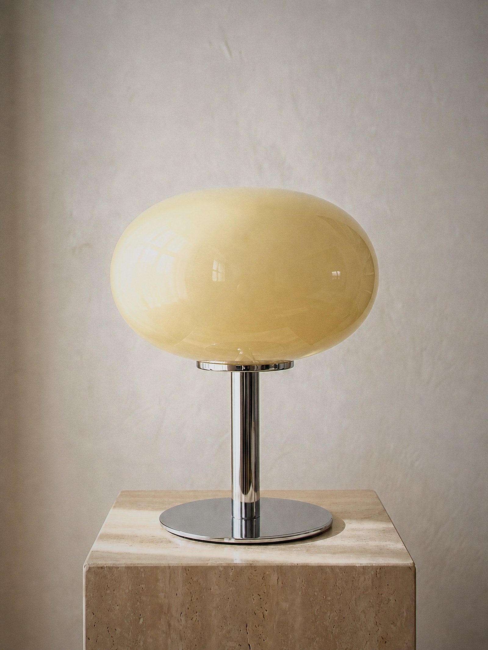 Halo, a soft cream frosted glass dome on a slim polished chrome base, unlit