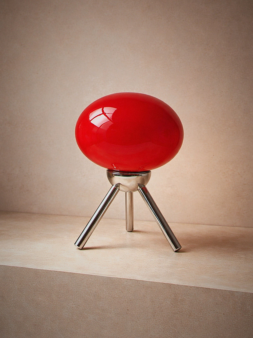 Prism, a red glass dome lamp on a polished chrome tripod, unlit