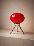 Prism, a red glass dome lamp on a polished chrome tripod, unlit
