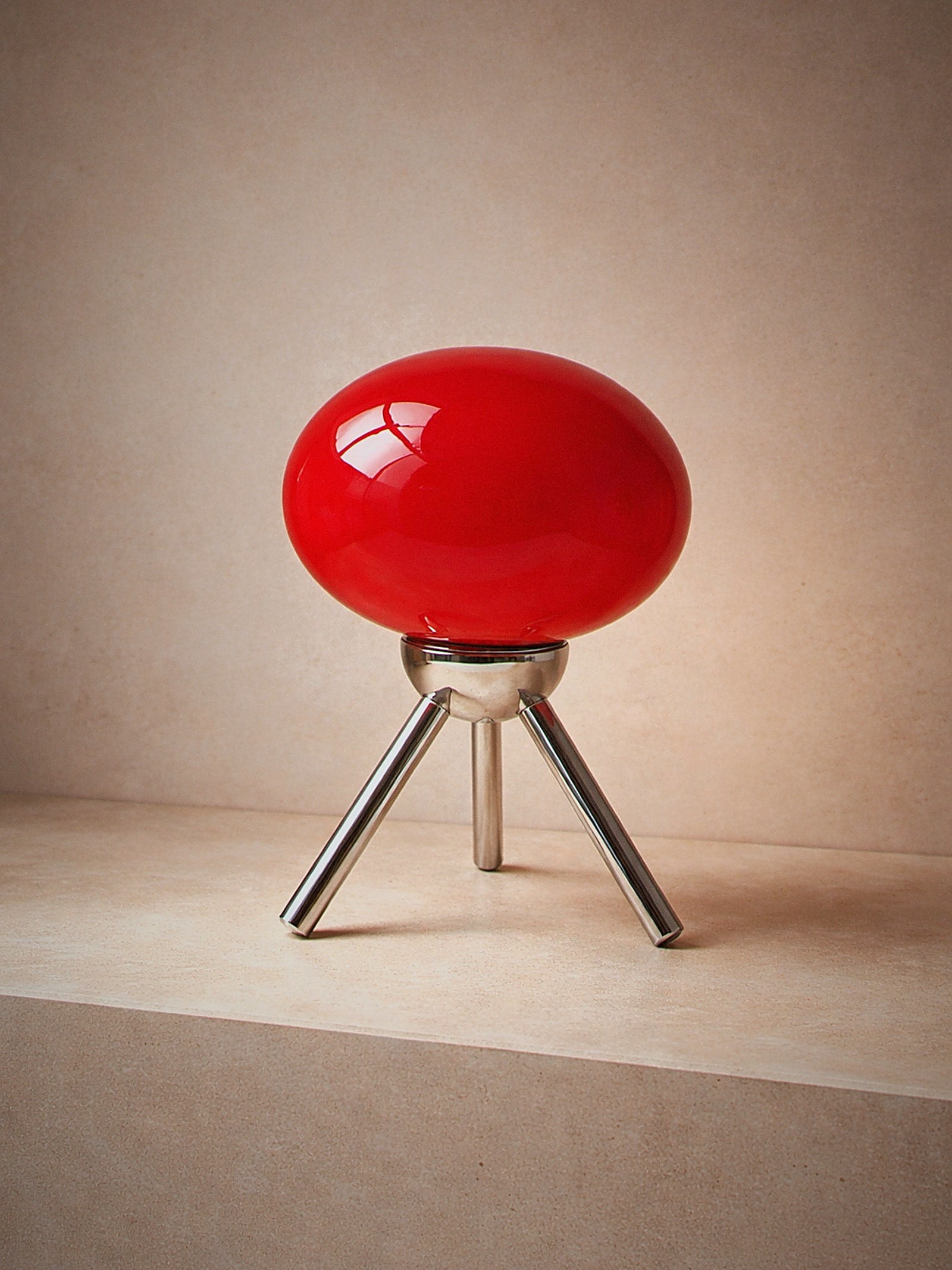 Prism, a red glass dome lamp on a polished chrome tripod, unlit