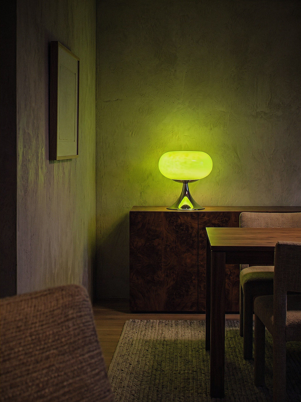 Rondo, a green glass dome on a polished chrome trumpet base lit as the only light source in an intimate dining nook