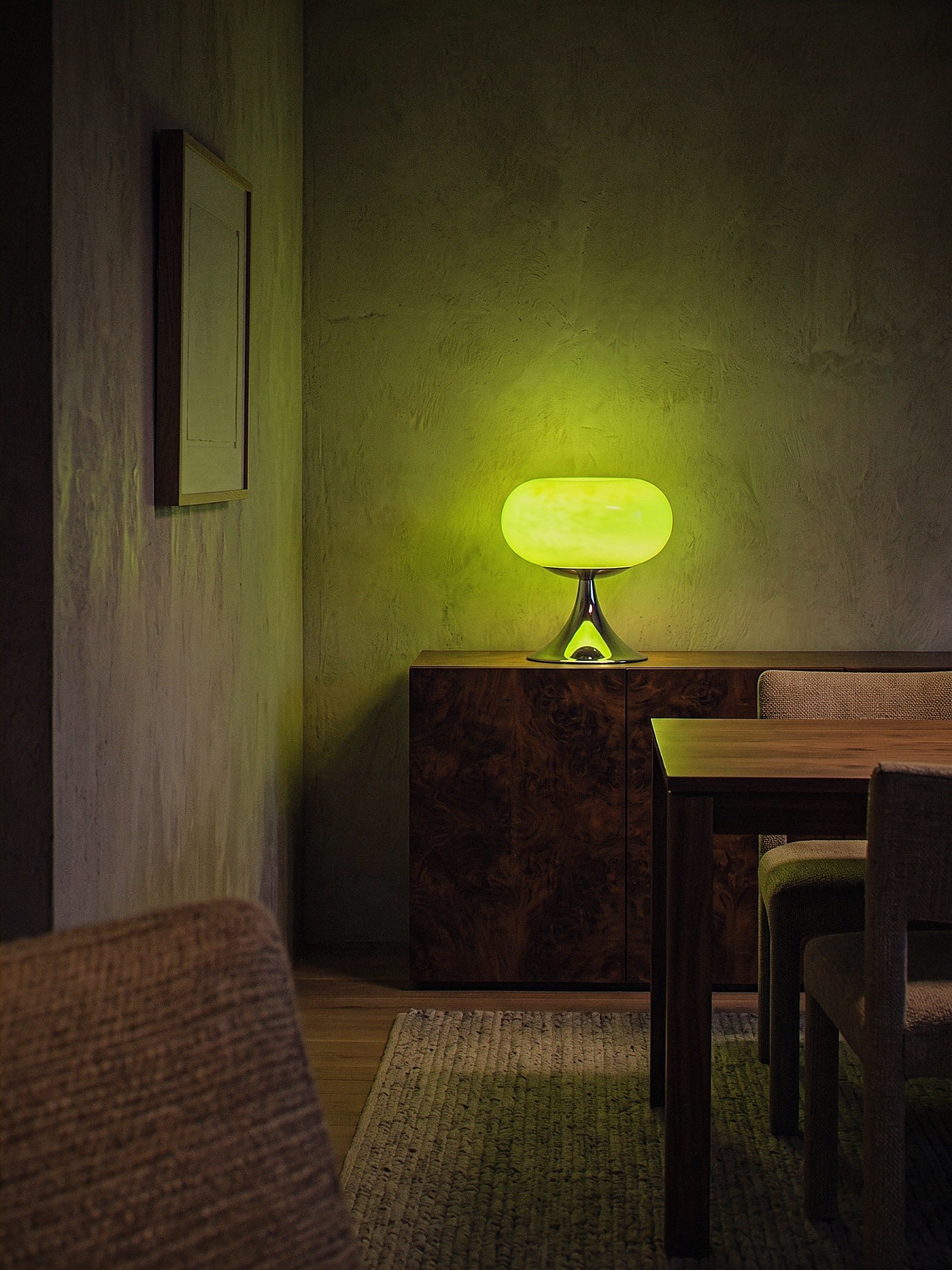 Rondo, a green glass dome on a polished chrome trumpet base lit as the only light source in an intimate dining nook