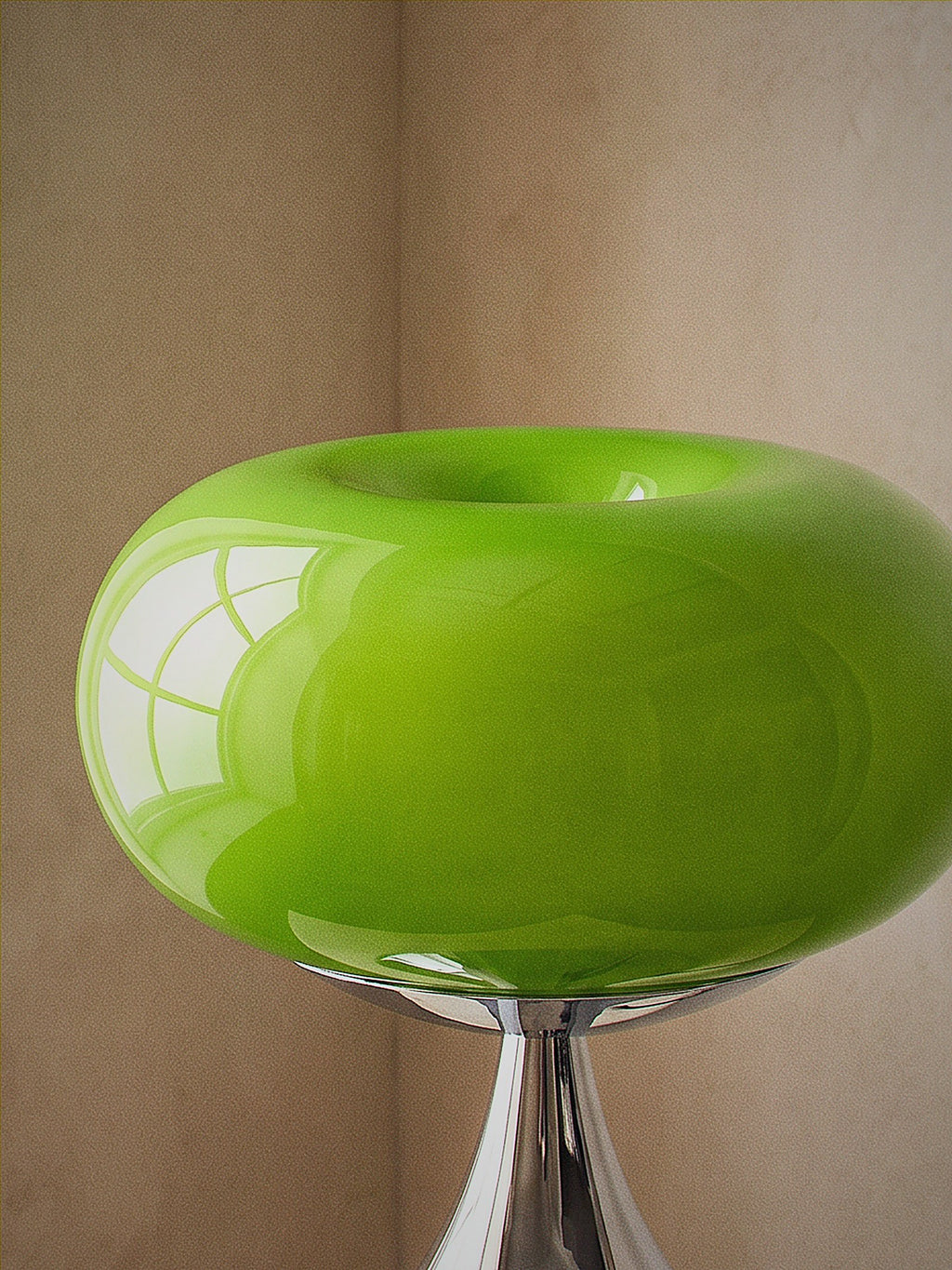 Close detail of Rondo, a green glass dome on a polished chrome trumpet base