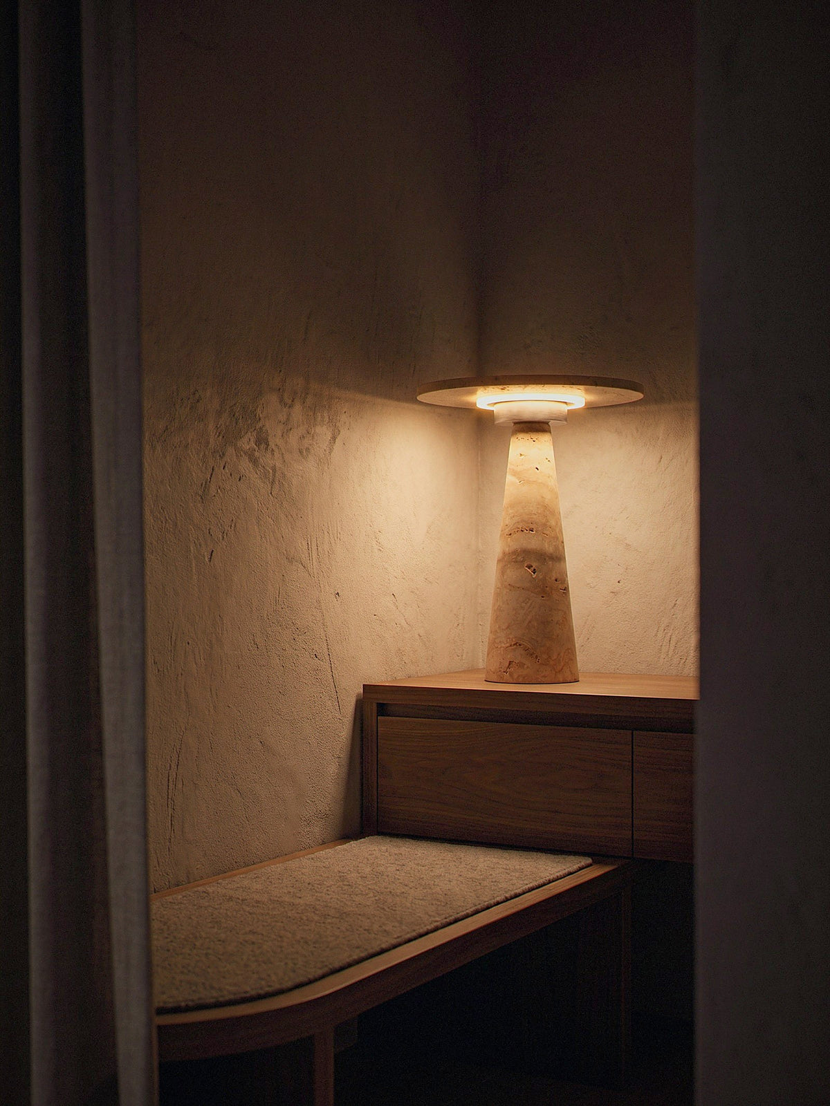 Terrazzo lit as the only light source on a bench in a quiet entry niche