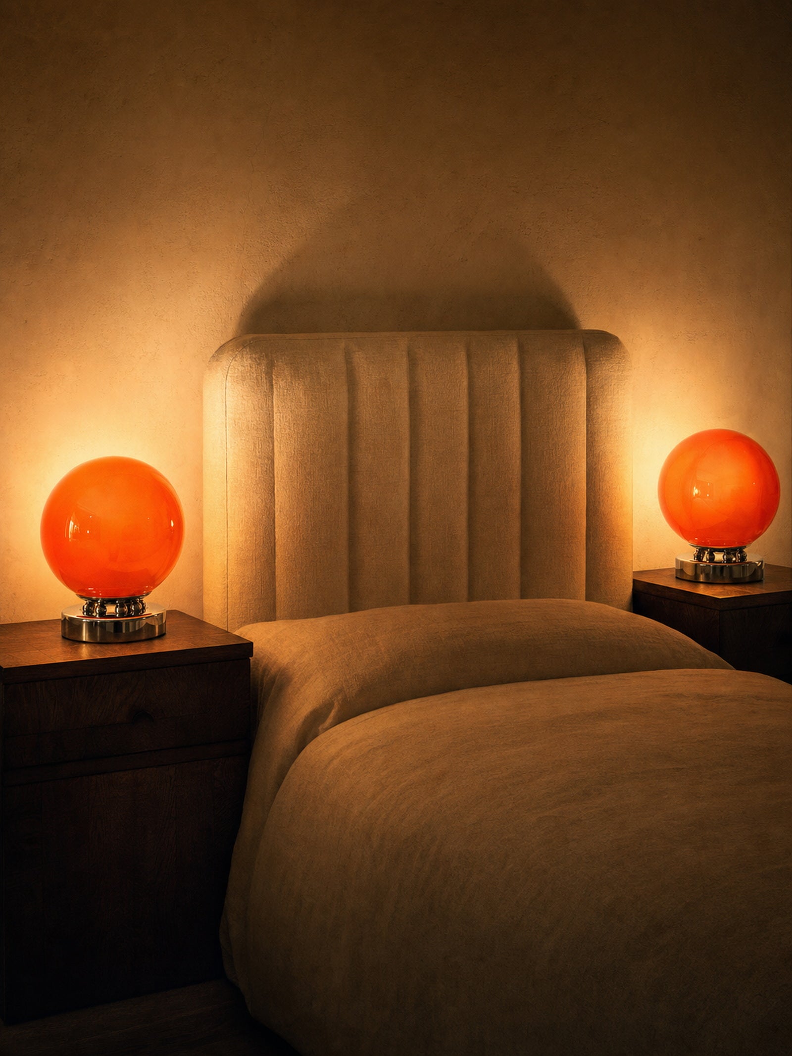 Two Whisper lamps lit on bedside tables either side of an upholstered bed, sold individually